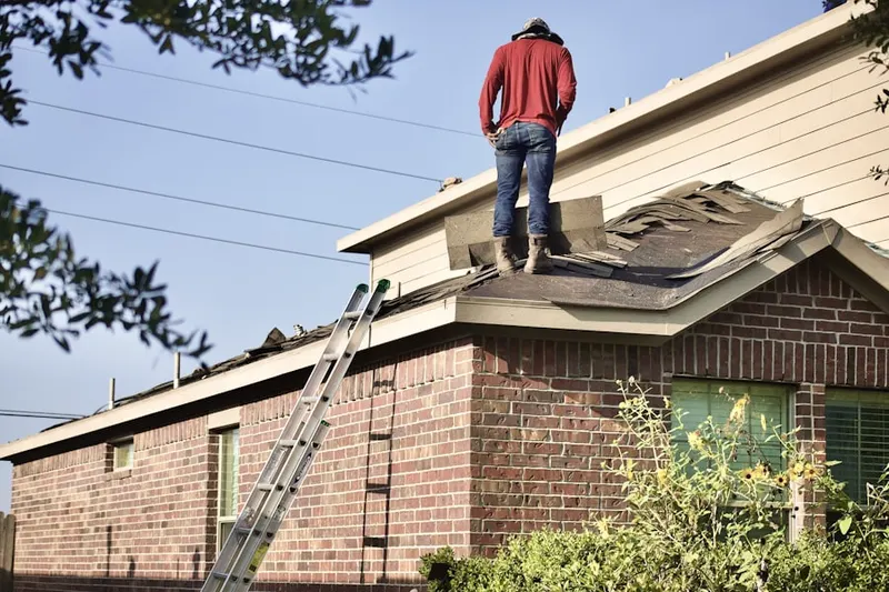 Professional roofer working on a residential roof in Little River Academy